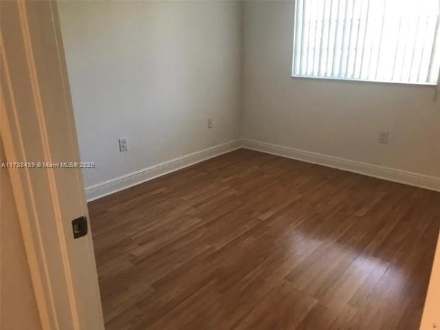 unfurnished room featuring dark hardwood / wood-style flooring