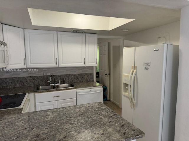 kitchen with light tile patterned flooring, sink, white cabinets, and white appliances