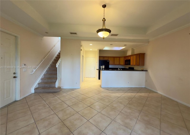 kitchen featuring visible vents, a raised ceiling, dark countertops, brown cabinets, and black appliances