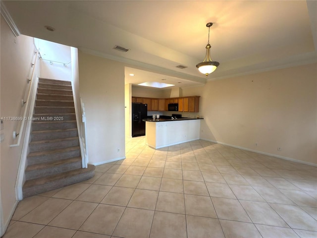 kitchen featuring a tray ceiling, dark countertops, visible vents, a peninsula, and black appliances