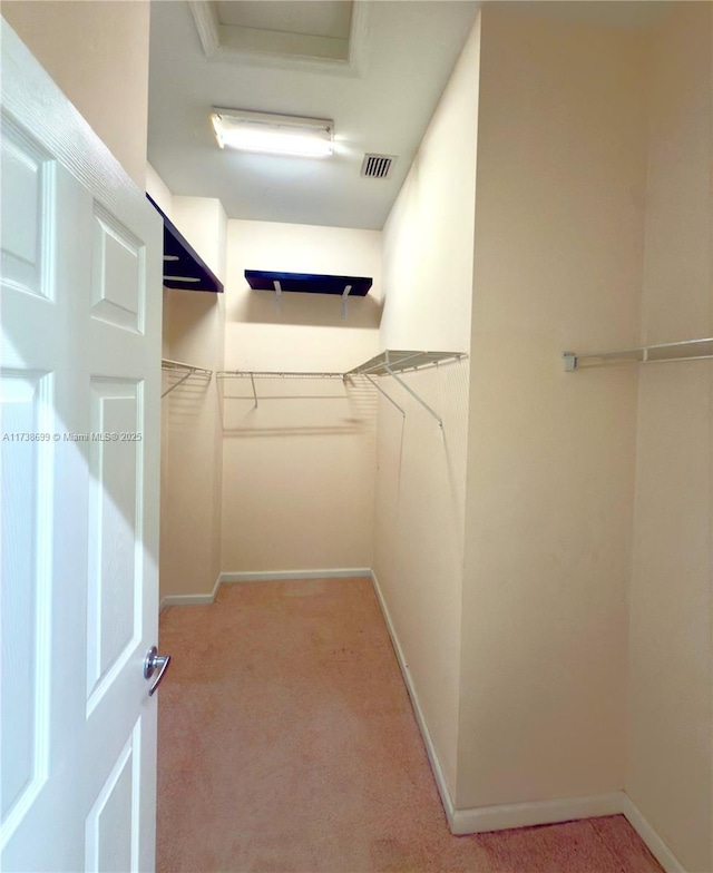 walk in closet with light carpet and visible vents