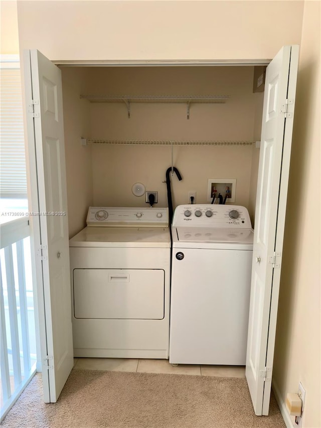 washroom with laundry area, light tile patterned floors, light colored carpet, and washing machine and clothes dryer