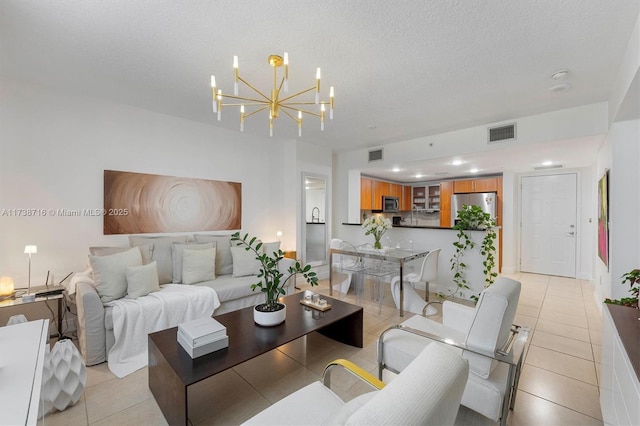 tiled living room with a notable chandelier and a textured ceiling