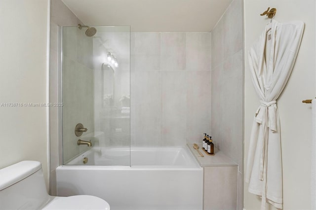 bathroom with toilet and tiled shower / bath combo