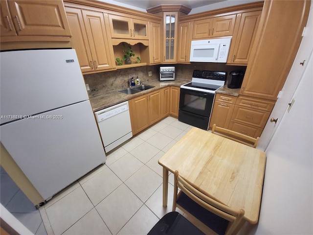 kitchen featuring sink, dark stone countertops, backsplash, light tile patterned floors, and white appliances