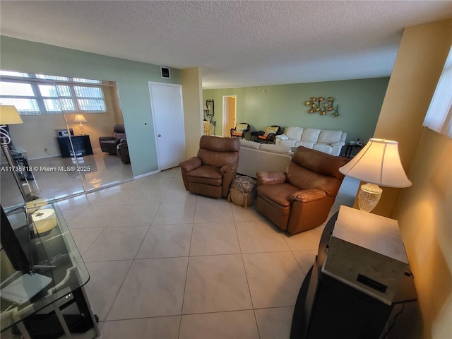 living room featuring a textured ceiling and light tile patterned floors