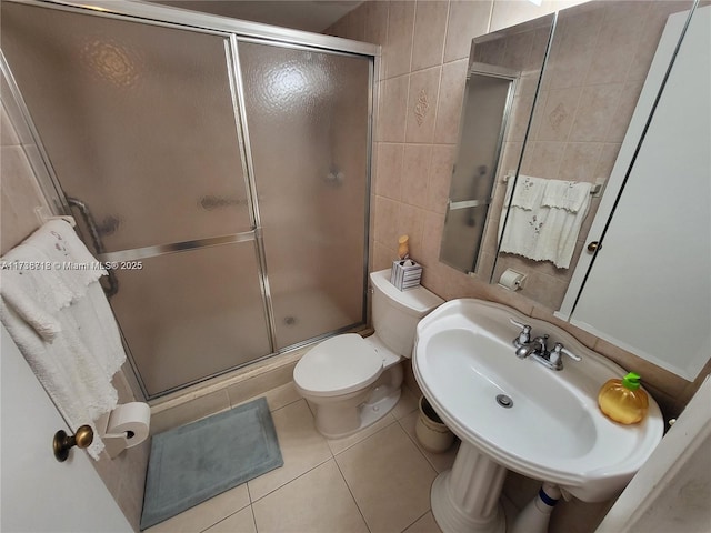 bathroom featuring sink, tile walls, tile patterned flooring, walk in shower, and toilet