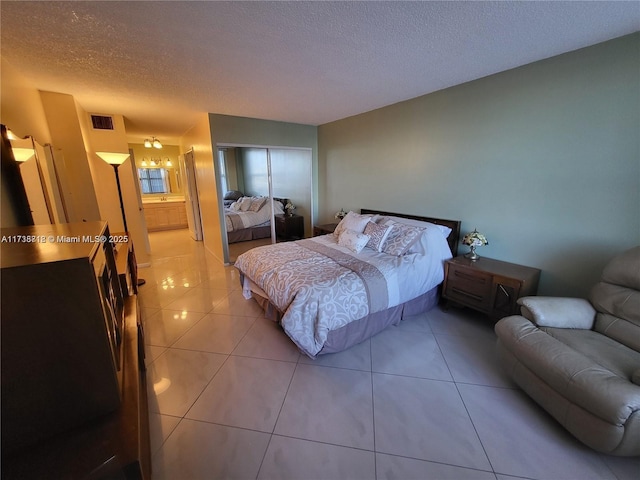 bedroom featuring light tile patterned flooring and a textured ceiling