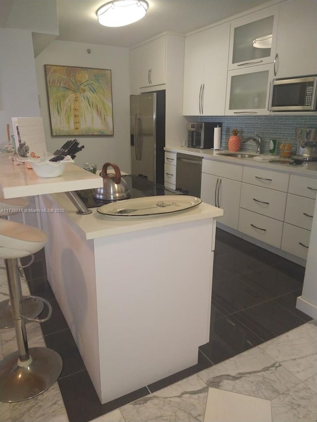 kitchen featuring white cabinetry, sink, tasteful backsplash, and appliances with stainless steel finishes