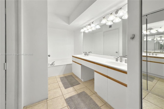 bathroom with tile patterned floors, a bath, and vanity