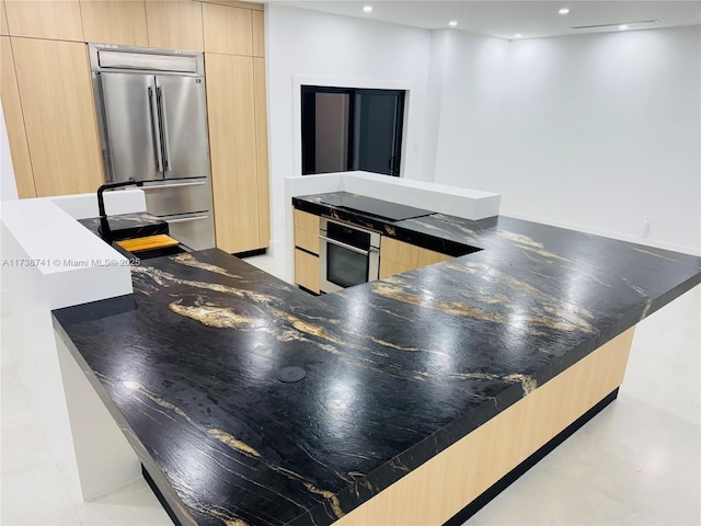 kitchen with modern cabinets, a peninsula, stainless steel appliances, light brown cabinets, and recessed lighting