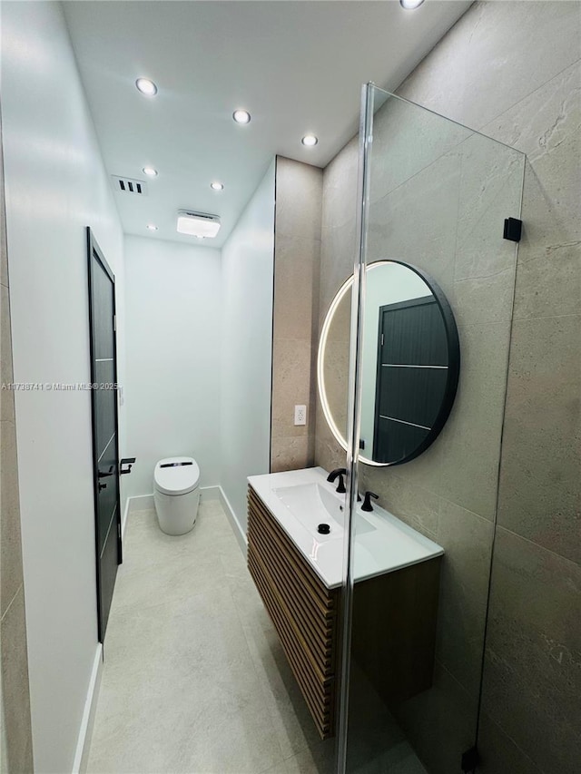 bathroom featuring vanity, walk in shower, and toilet