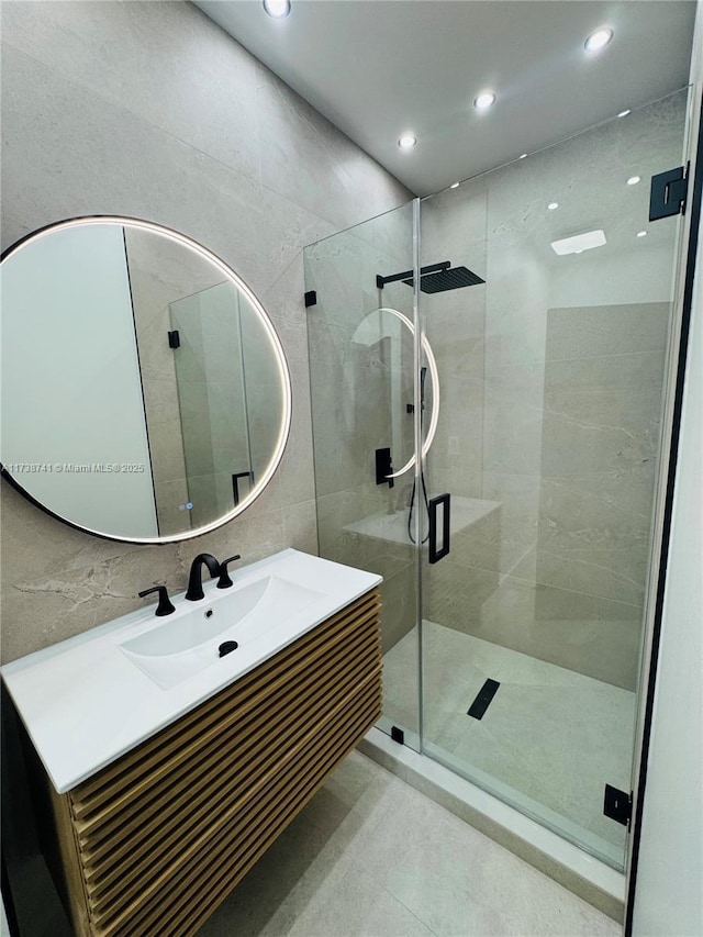 bathroom featuring vanity, tile walls, and walk in shower