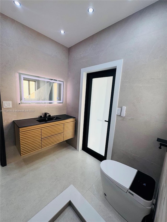 bathroom with tile patterned flooring, vanity, and tile walls