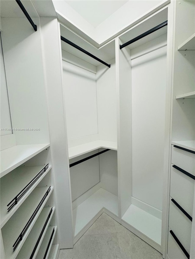 spacious closet featuring light tile patterned floors