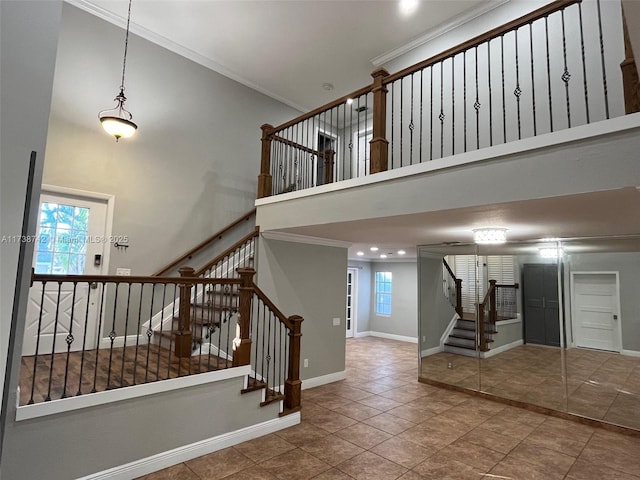 stairway with a towering ceiling, ornamental molding, and tile patterned floors