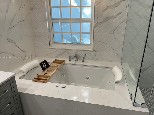 bathroom featuring a washtub and vanity