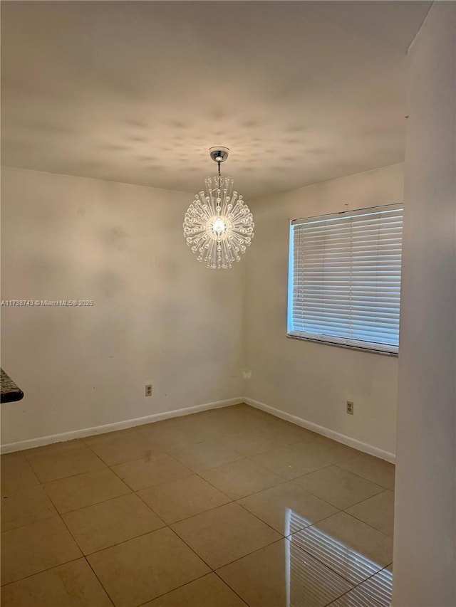 spare room with tile patterned flooring and a chandelier