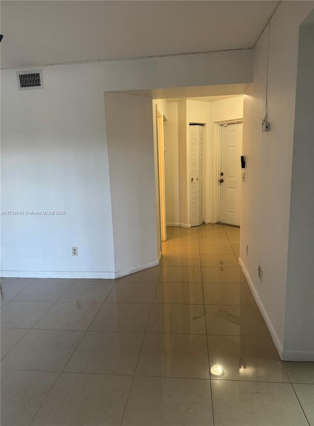 hall featuring light tile patterned flooring