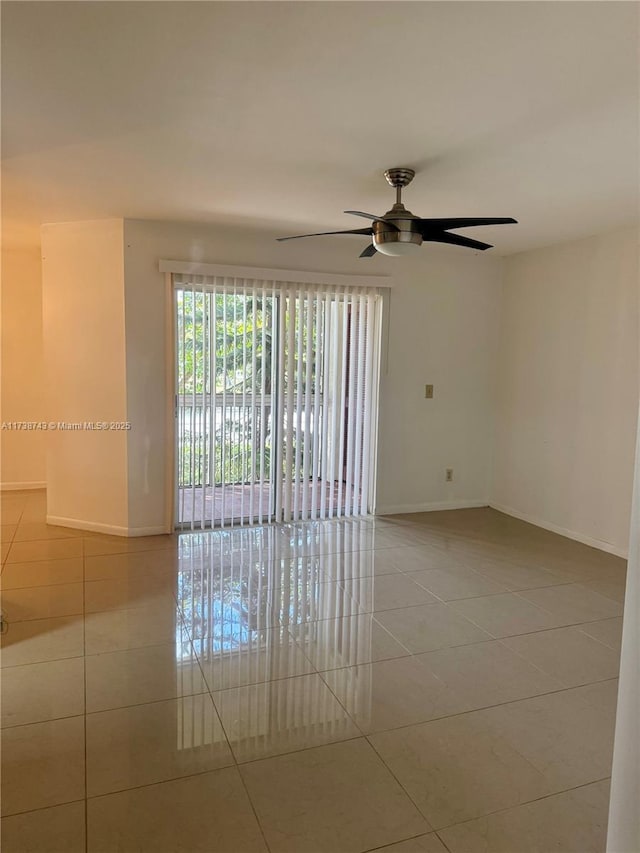 tiled empty room featuring ceiling fan