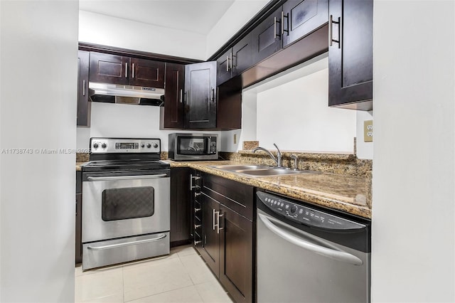 kitchen featuring stainless steel appliances, sink, dark brown cabinets, light tile patterned floors, and stone counters