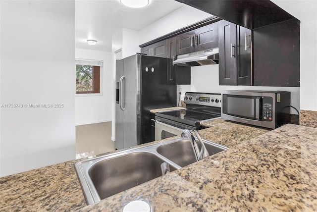 kitchen featuring dark brown cabinetry, stainless steel appliances, stone countertops, and sink