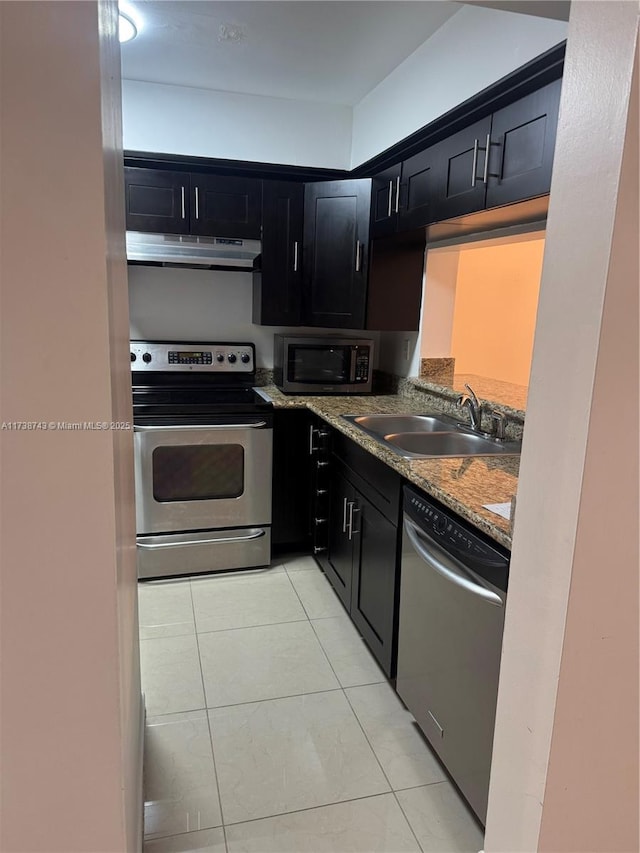 kitchen with light stone countertops, appliances with stainless steel finishes, sink, and light tile patterned floors