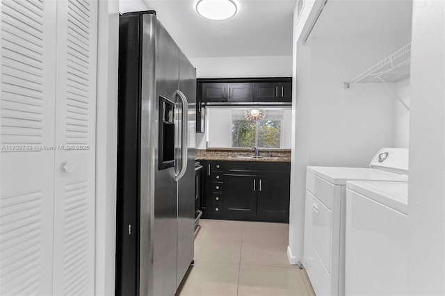 washroom featuring sink, light tile patterned flooring, and washer and clothes dryer