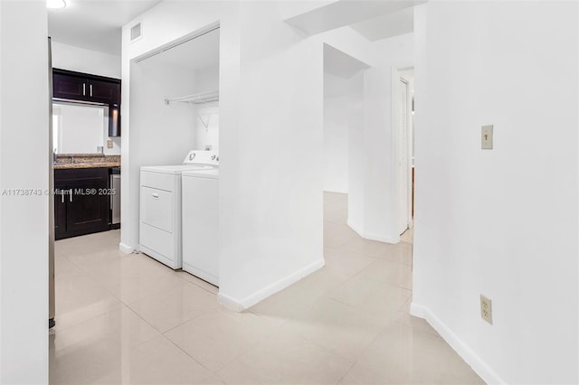 corridor with light tile patterned floors and washing machine and clothes dryer