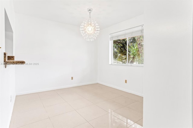 tiled empty room featuring a chandelier