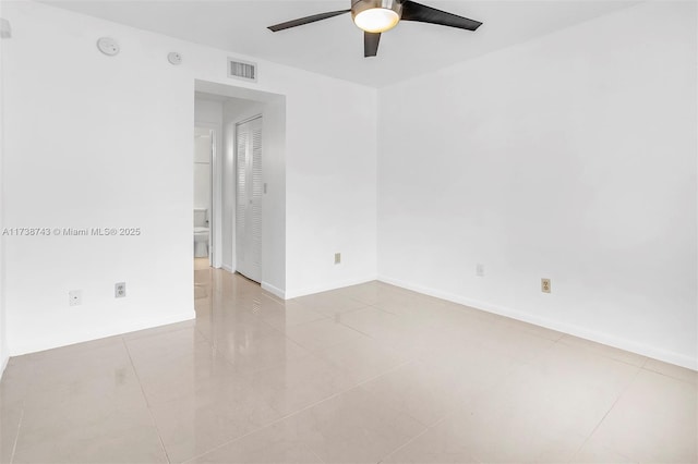 tiled spare room with ceiling fan