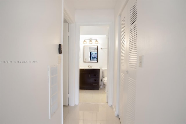 hall featuring light tile patterned floors and sink