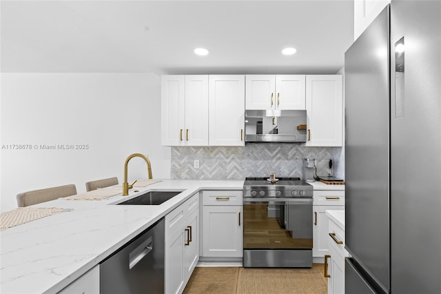 kitchen with a breakfast bar, sink, white cabinets, decorative backsplash, and stainless steel appliances