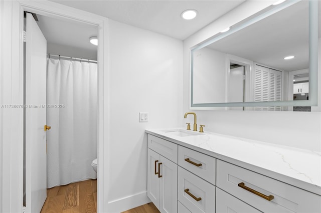 bathroom featuring hardwood / wood-style flooring, vanity, and toilet