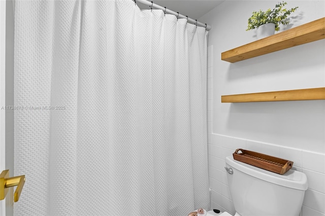 bathroom with tile walls and toilet