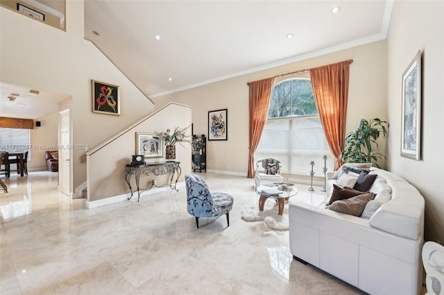 sitting room with a towering ceiling and ornamental molding