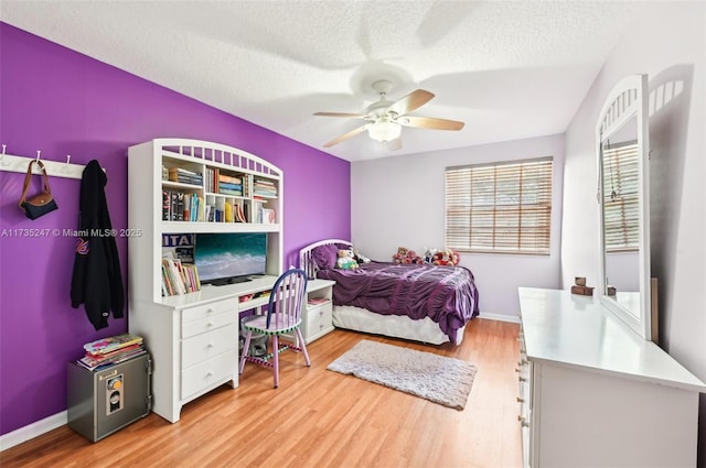 bedroom featuring ceiling fan, a textured ceiling, and light wood-type flooring