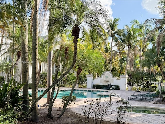 view of swimming pool with a patio area and a hot tub