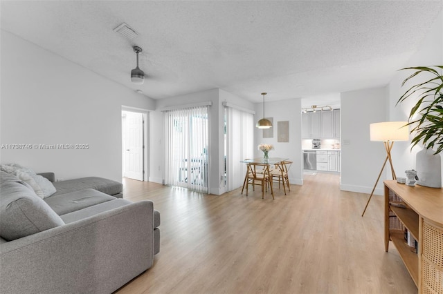 living room featuring light hardwood / wood-style floors and a textured ceiling