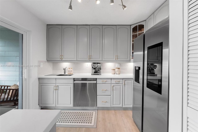 kitchen featuring gray cabinets, light wood-type flooring, and decorative backsplash