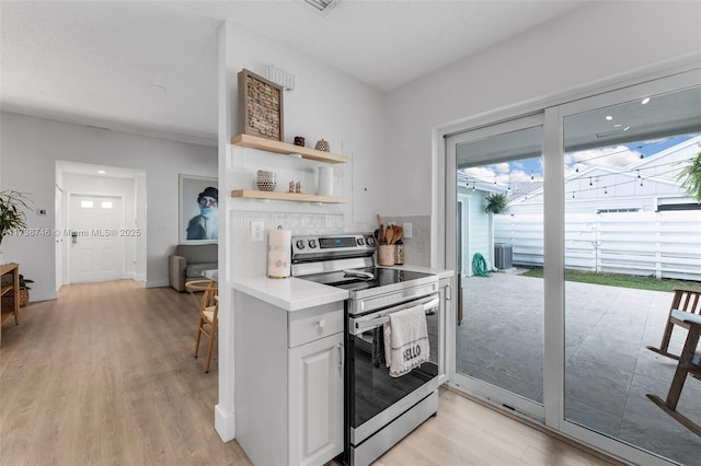 kitchen featuring white cabinetry, tasteful backsplash, light hardwood / wood-style flooring, and electric range