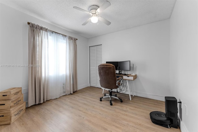 office area with ceiling fan, light hardwood / wood-style floors, and a textured ceiling