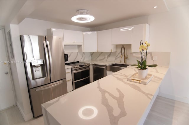 kitchen featuring sink, white cabinets, backsplash, kitchen peninsula, and stainless steel appliances