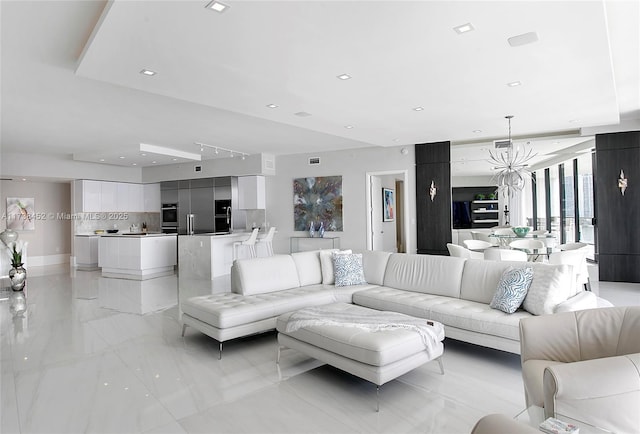 living room with recessed lighting and an inviting chandelier