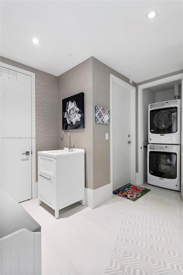 laundry room with stacked washer / drying machine, laundry area, a sink, and recessed lighting