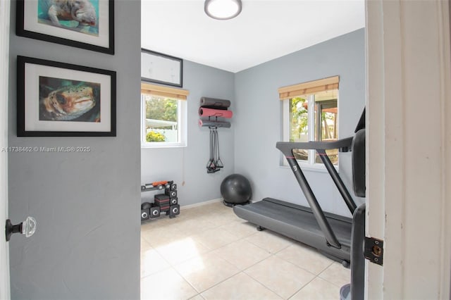 exercise area featuring light tile patterned floors and a wealth of natural light