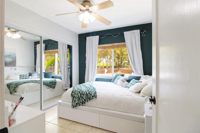 tiled bedroom with multiple windows, ceiling fan, and a closet