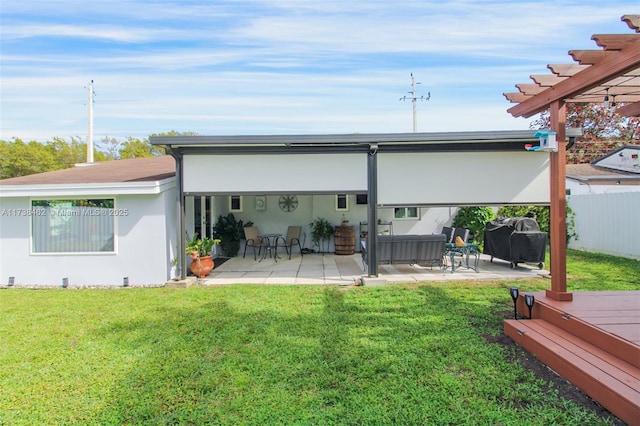 rear view of property with a wooden deck, a pergola, a lawn, and a patio