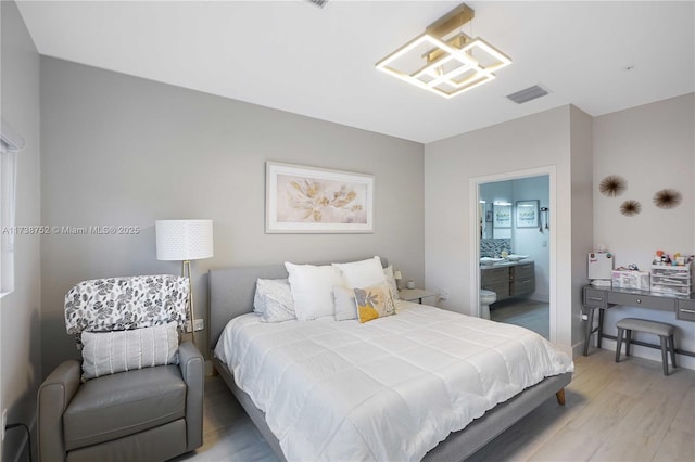 bedroom with hardwood / wood-style flooring and ensuite bathroom