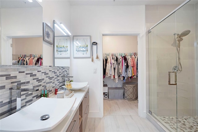 bathroom featuring tasteful backsplash, vanity, and an enclosed shower